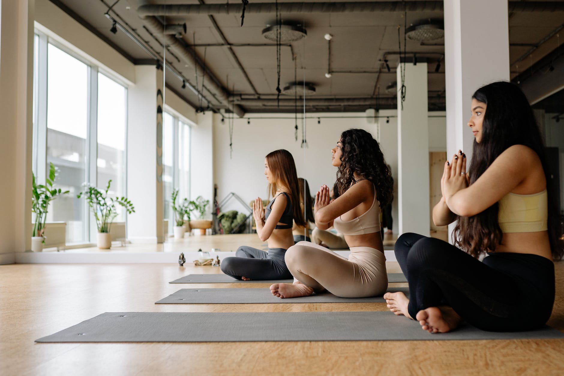 three women meditating in a yoga class